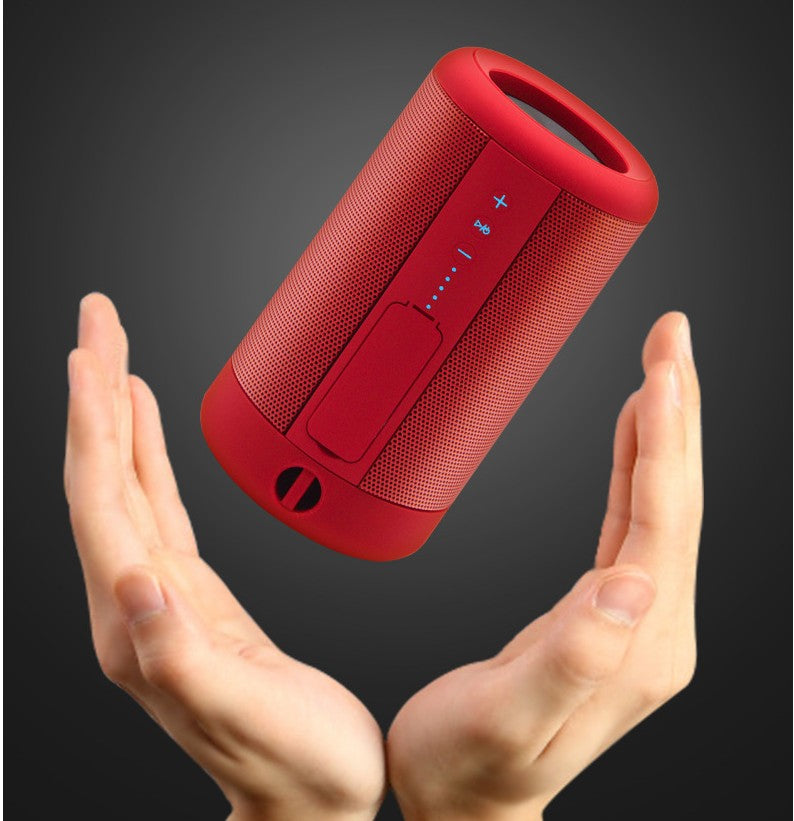 Axendris portable red wireless Bluetooth speaker floating above hands, featuring a durable, waterproof design.